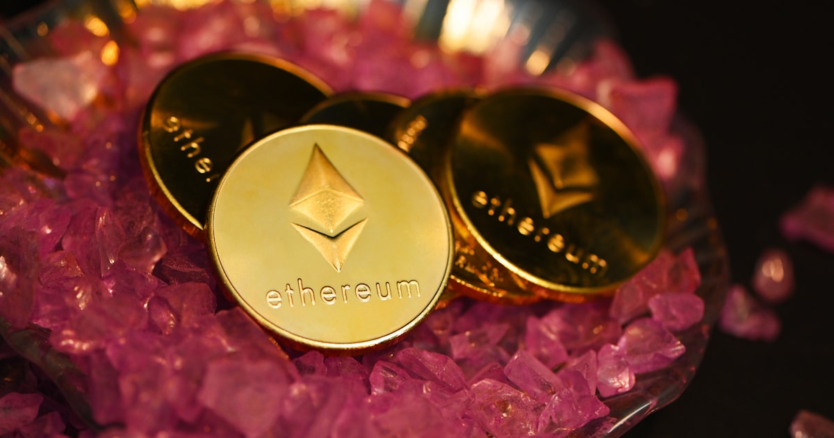 two gold coin sitting on top of a pile of pink crystals