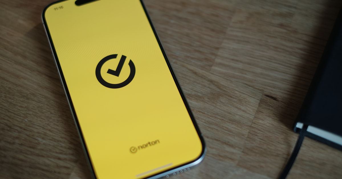 A yellow cell phone sitting on top of a wooden table