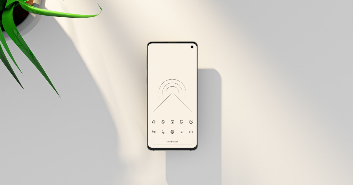 a cell phone sitting on top of a table next to a plant