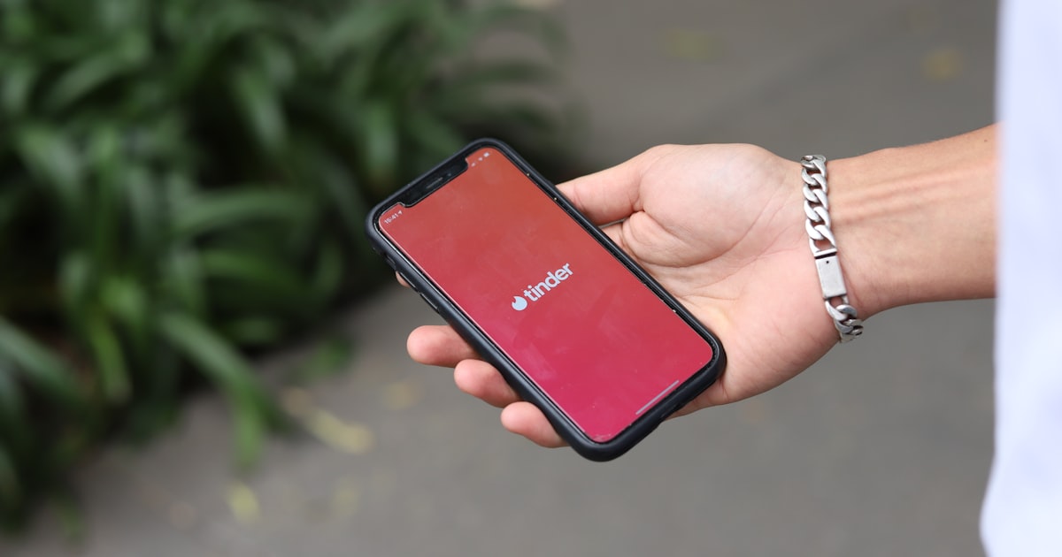 a person holding a red cell phone in their hand
