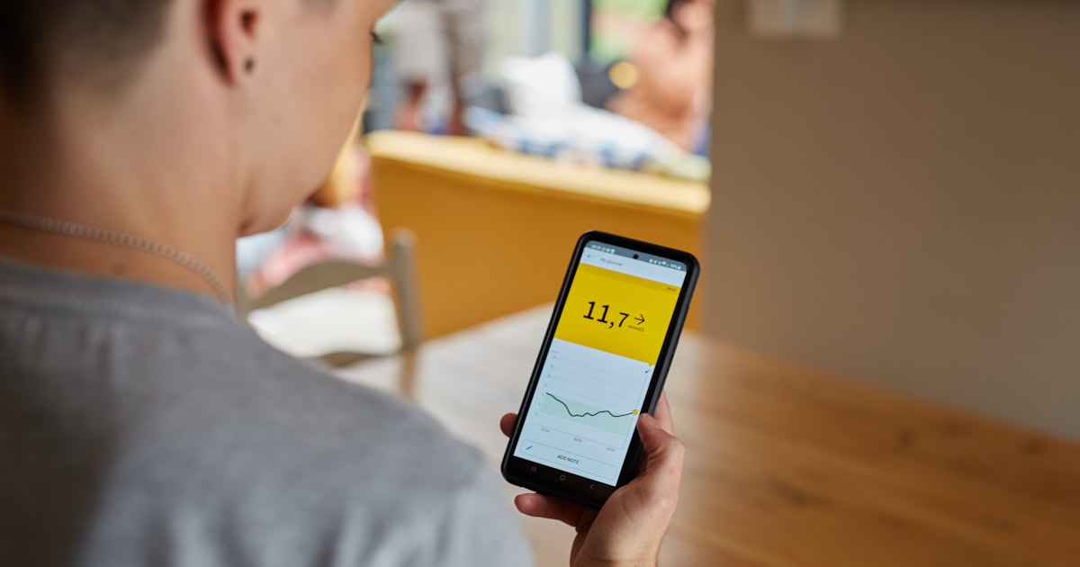 a person looks at high blood glucose results on smart phone