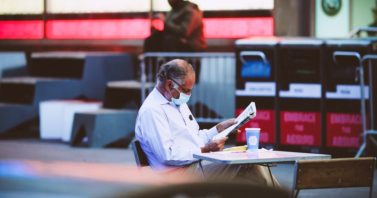 man in blue dress shirt reading book