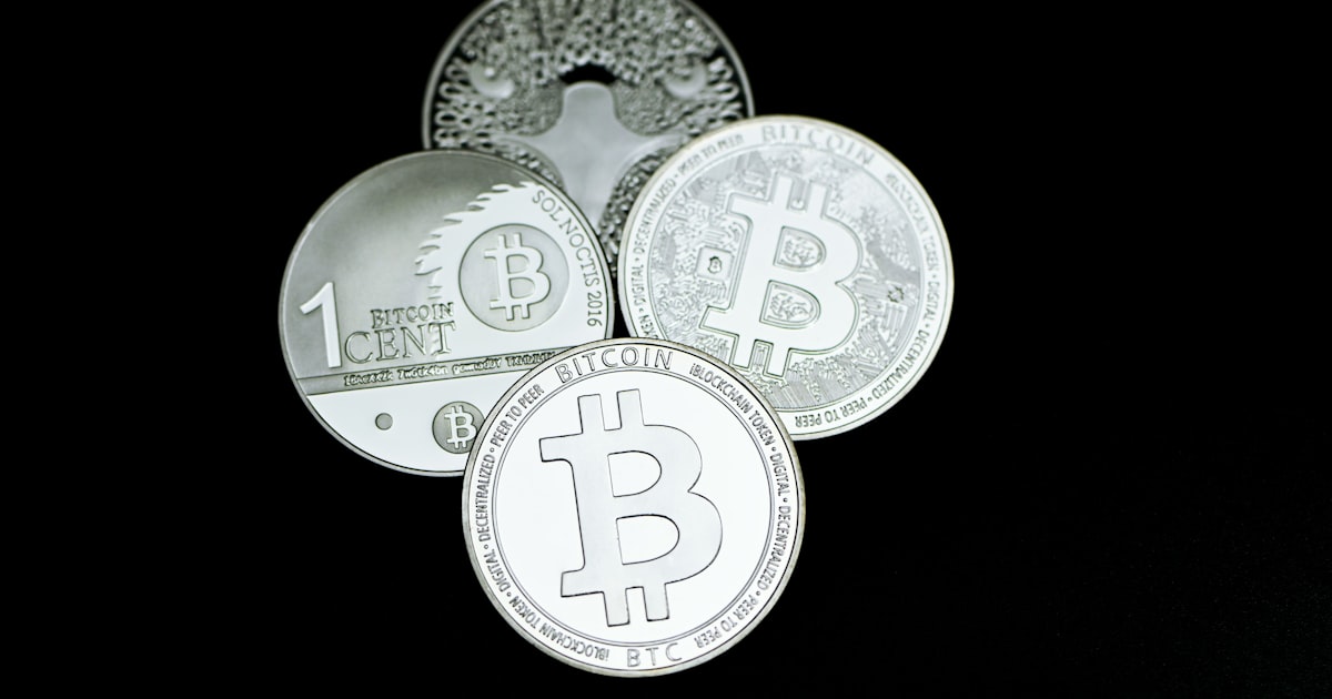 a pile of silver bitcoins sitting on top of each other