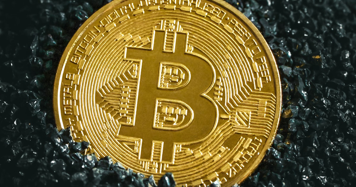 a bitcoin sitting on top of a black surface
