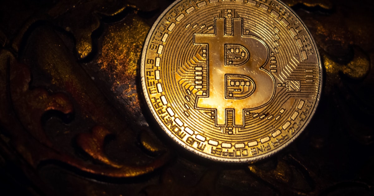 gold round coin on black surface