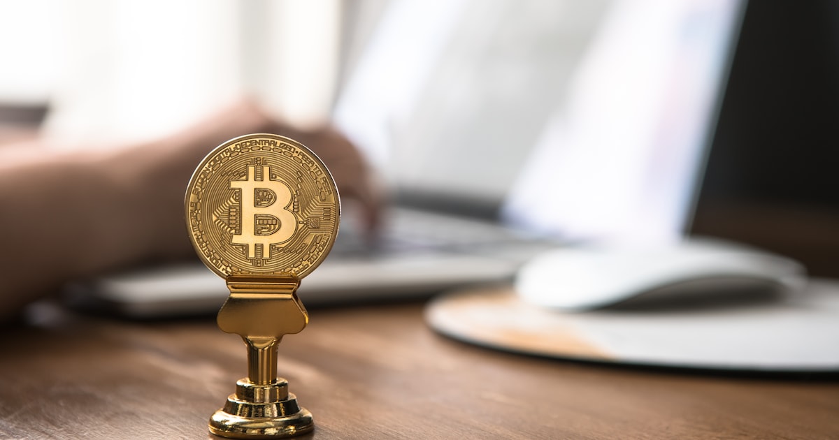 gold-colored bitcoin on brown table