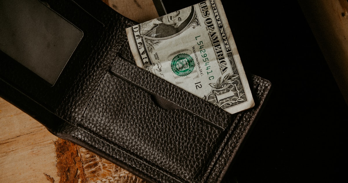 a wallet with a dollar bill sticking out of it