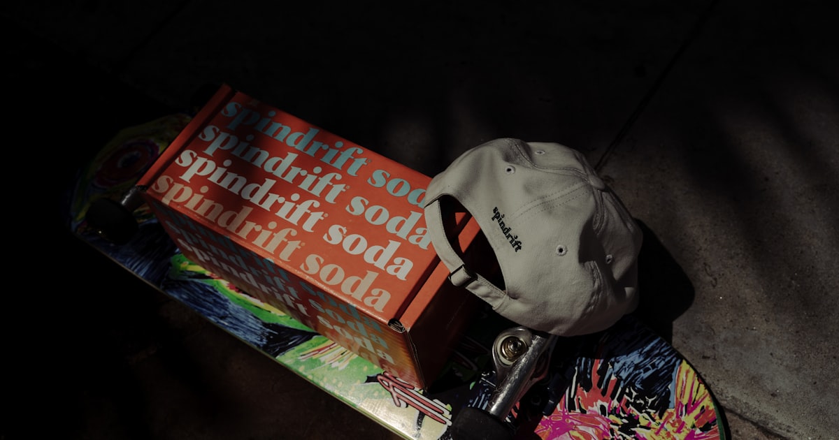 Spindrift soda box on a skateboard with a hat