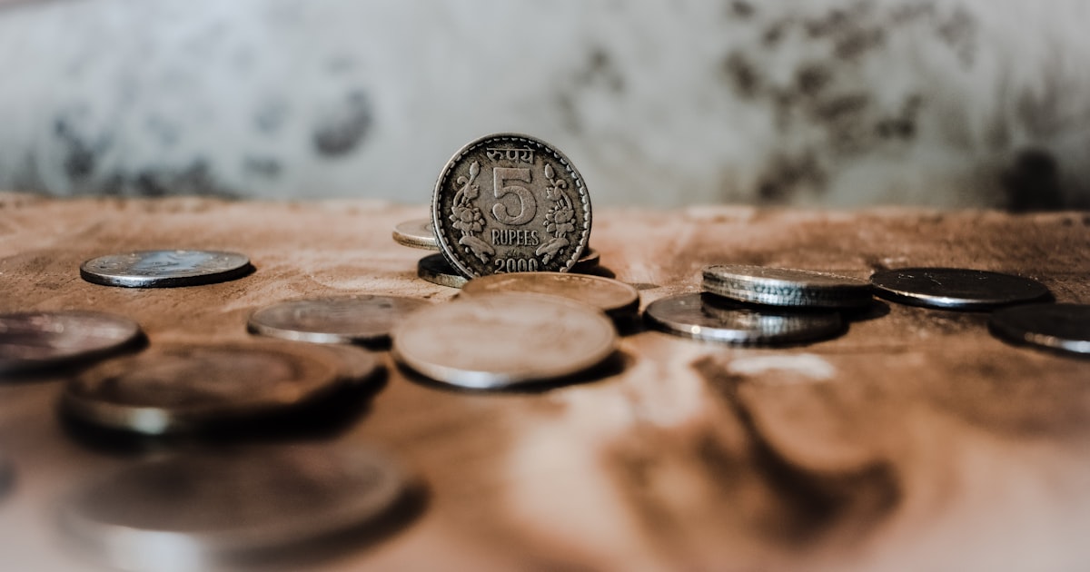 Several coins scattered on a textured surface.