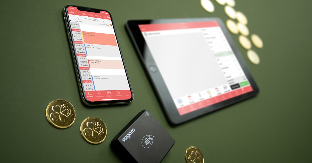 Smartphone, tablet, payment terminal, and coins on table
