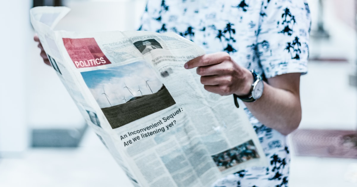 selective focus photography of person holding newspaper