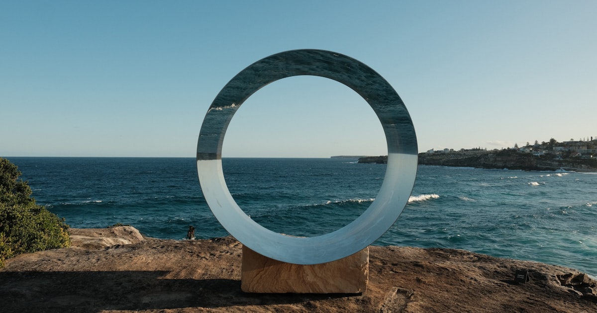 A sculpture on top of a hill near the ocean