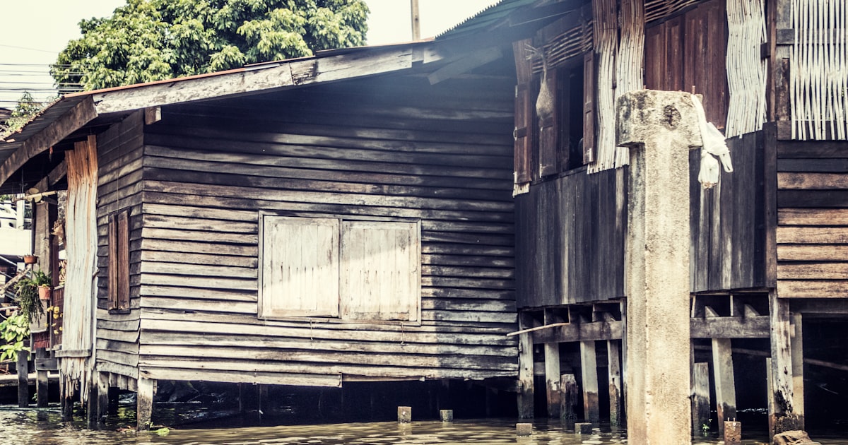 brown and gray house beside body of water