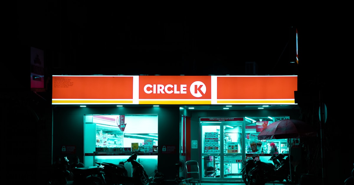a store front at night with a motorcycle parked in front of it