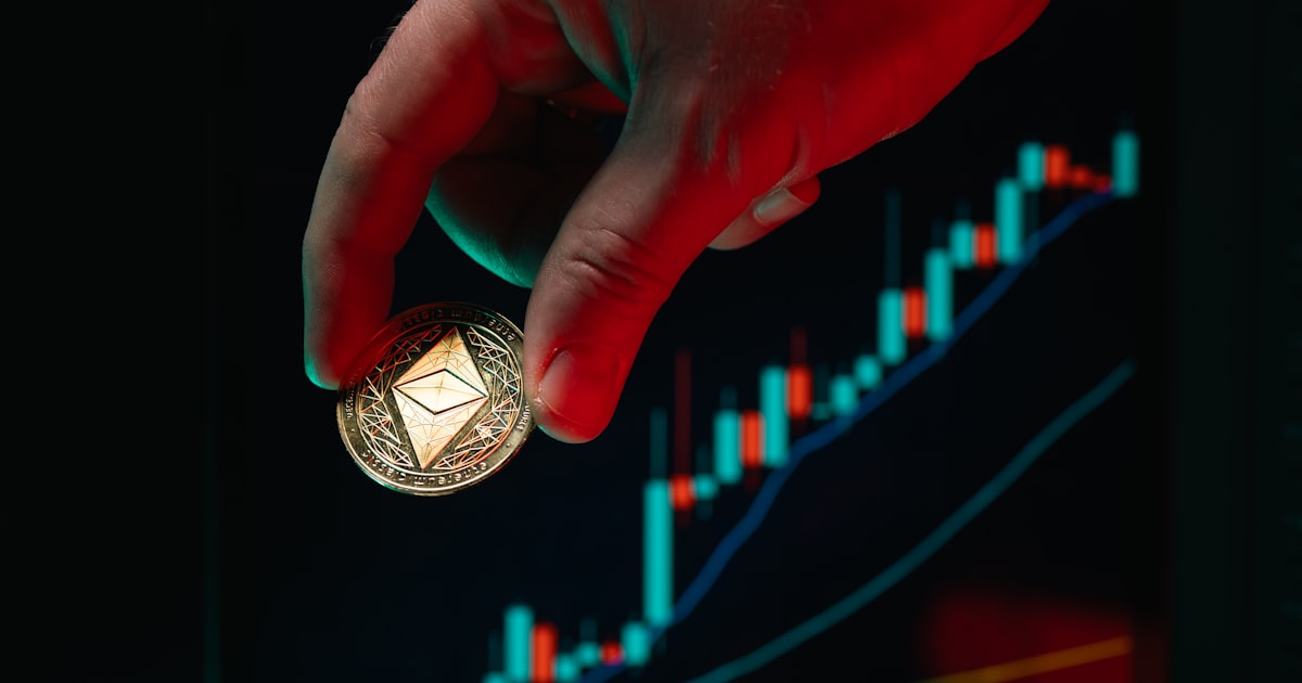 Hand holds ethereum coin over the stock chart.