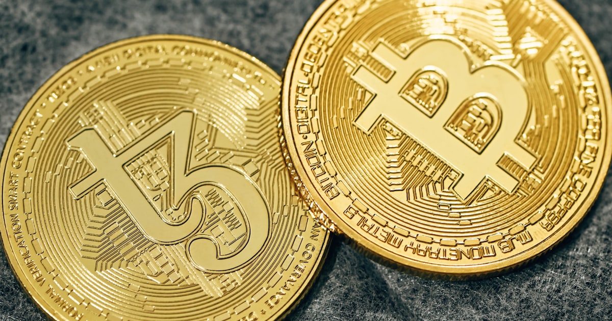 two gold bitcoins sitting side by side