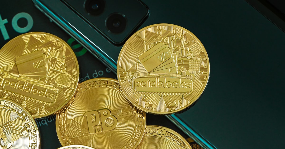 a pile of gold coins next to a cell phone