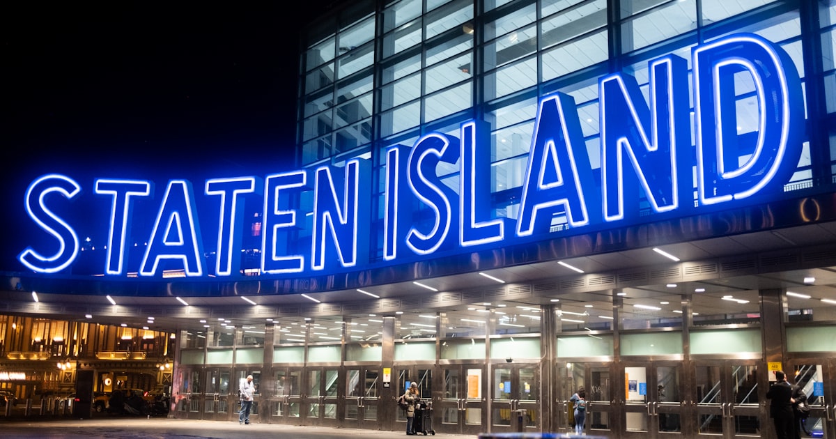 a building with a neon sign that reads state island