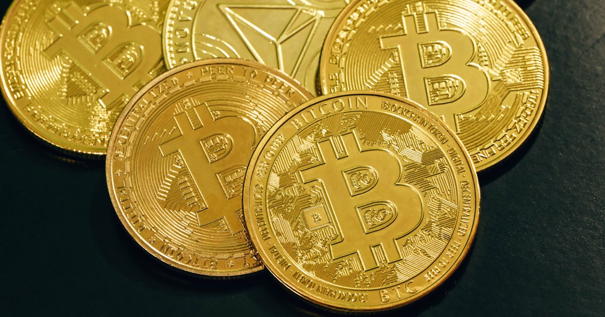 a pile of gold bitcoins sitting on top of a table