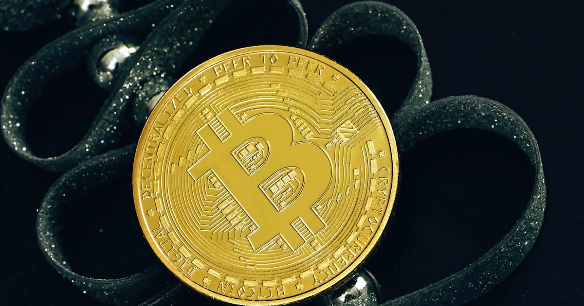 a bit coin sitting on top of a pair of scissors