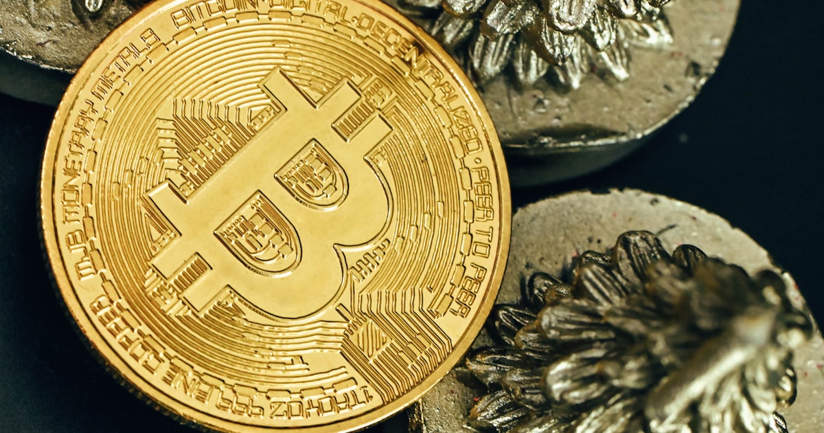 a bitcoin sitting on top of a pile of coins