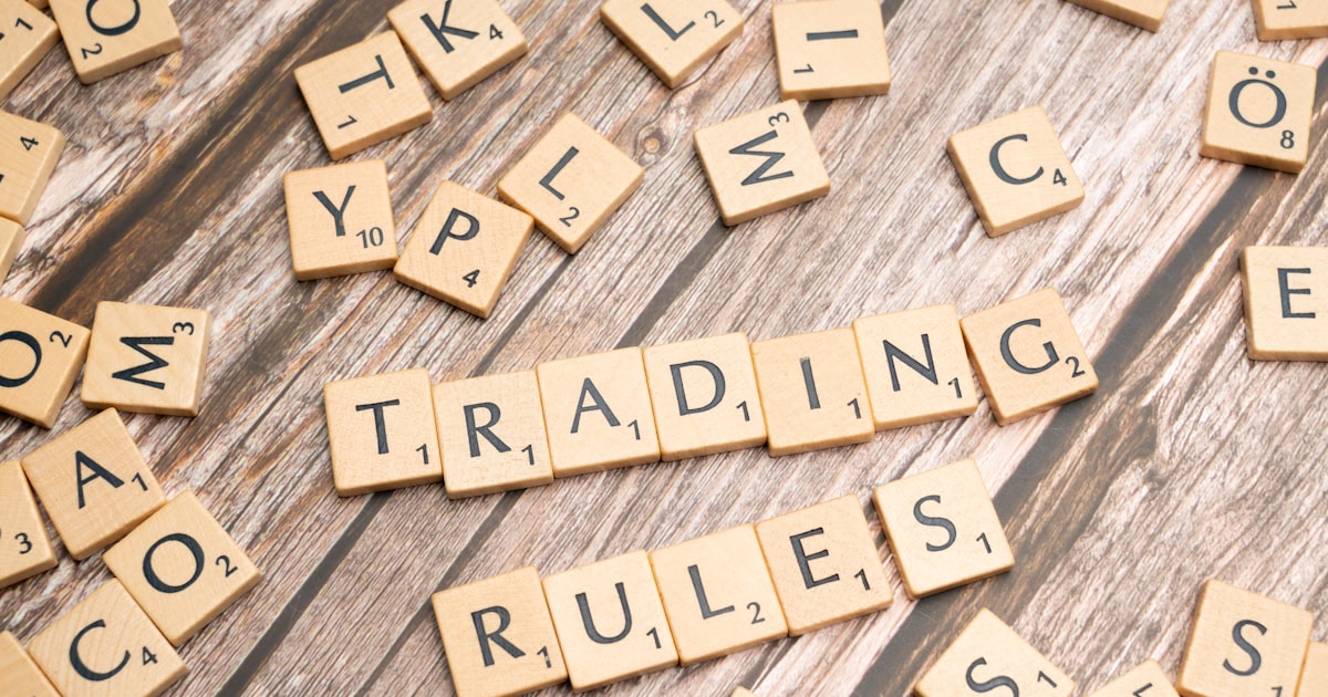 scrabble tiles spelling trading rules on a wooden table