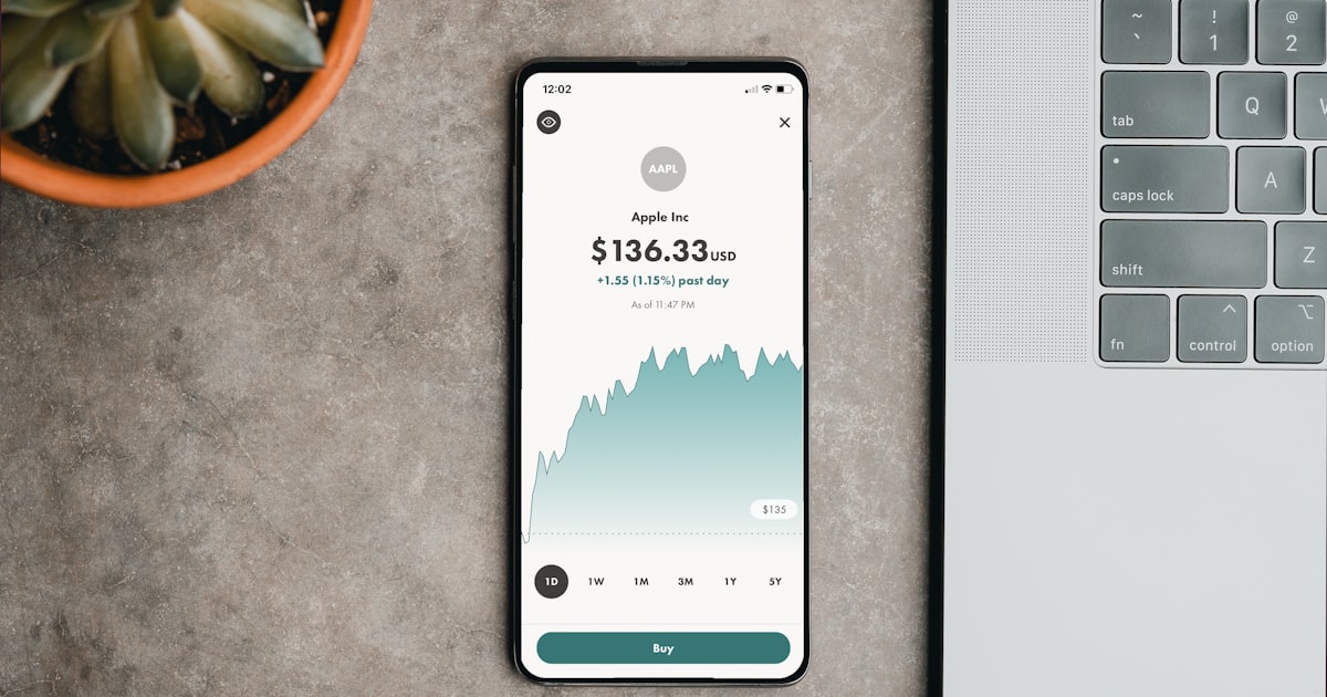 a cell phone sitting on top of a table next to a laptop