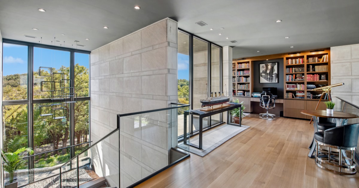 Modern home office with large windows and bookshelves