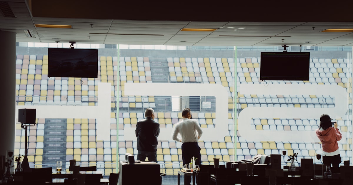 people standing in front of a large screen