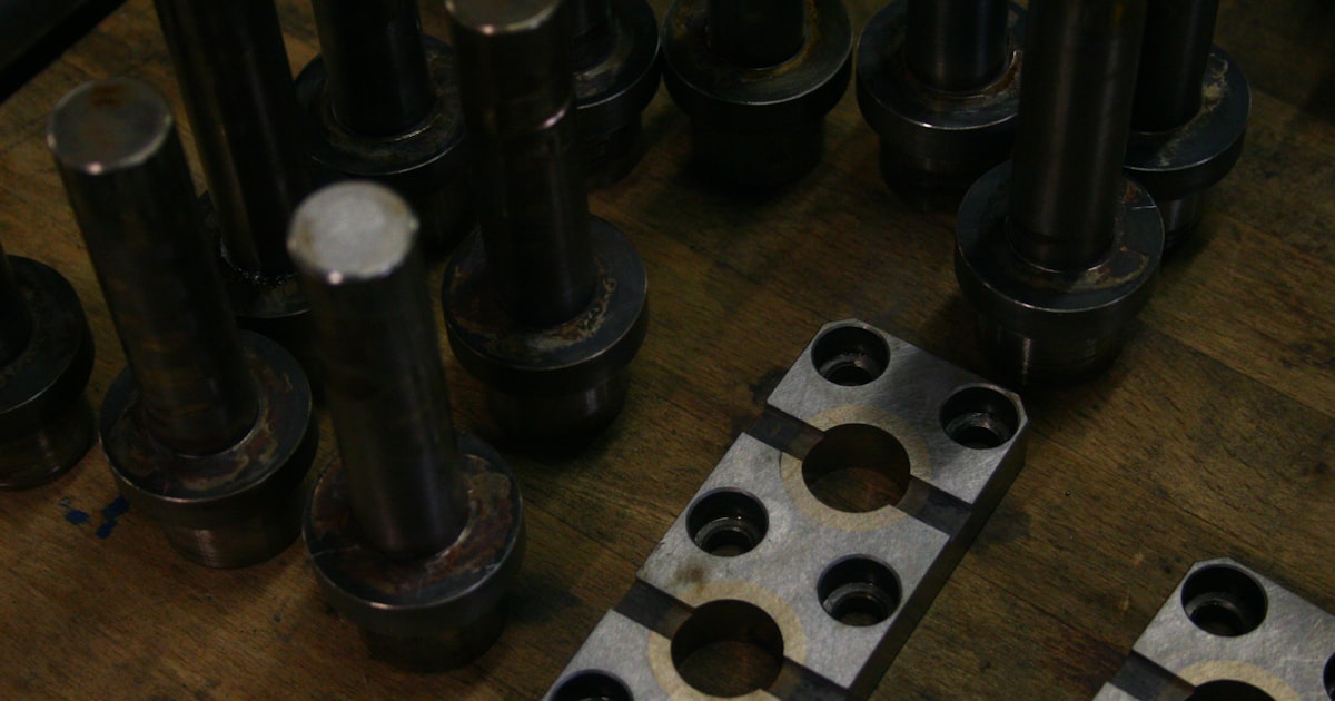 Metal parts and components arranged on a wooden surface.