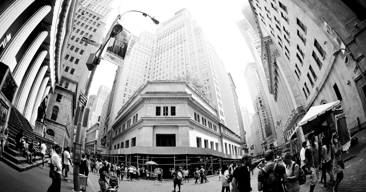 grayscale photo of people walking on street near building