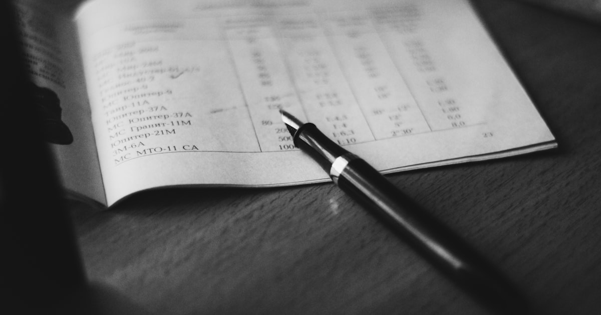 grayscale photography of pen near printer paper