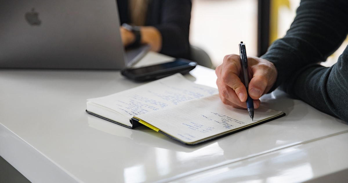 person writing on white paper