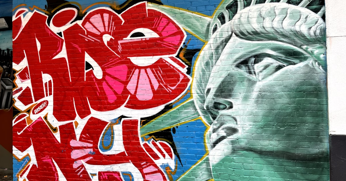 a mural of the statue of liberty painted on a brick wall