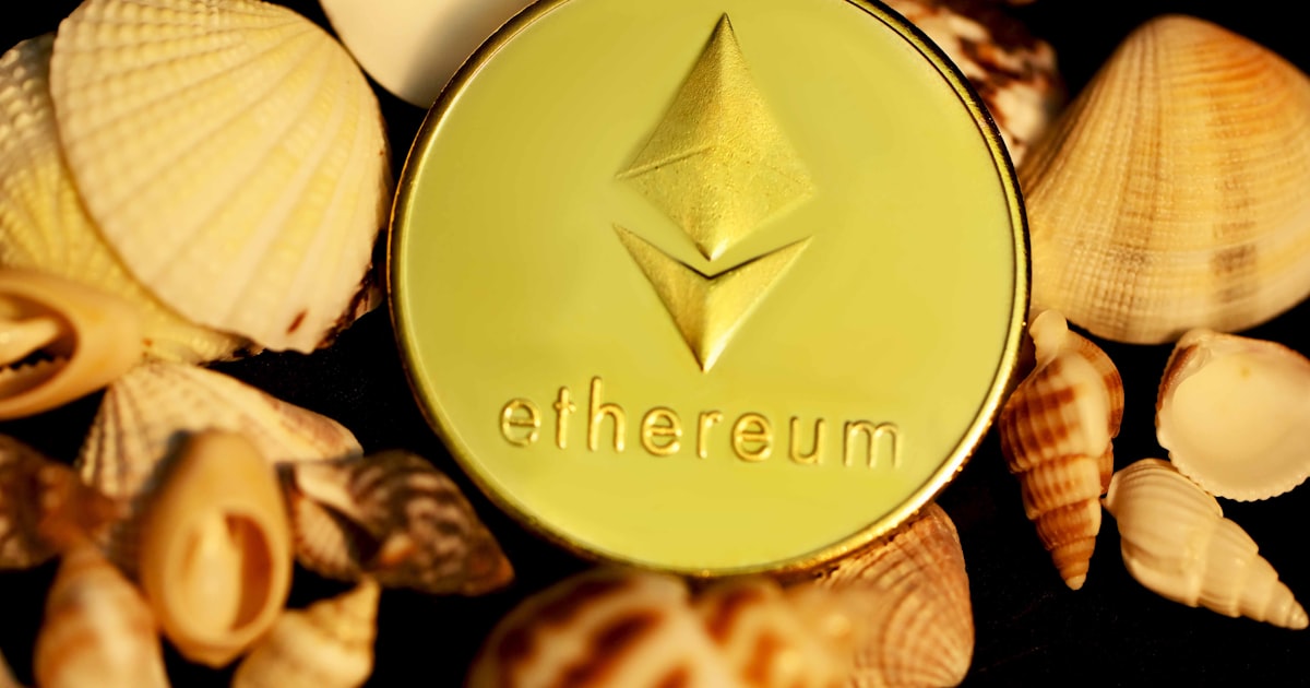 a gold ether coin surrounded by shells