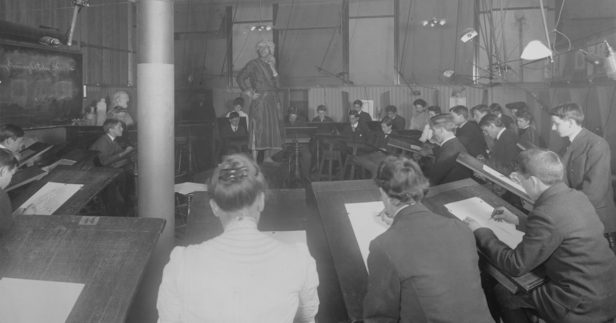 a group of men sitting at desks in a room