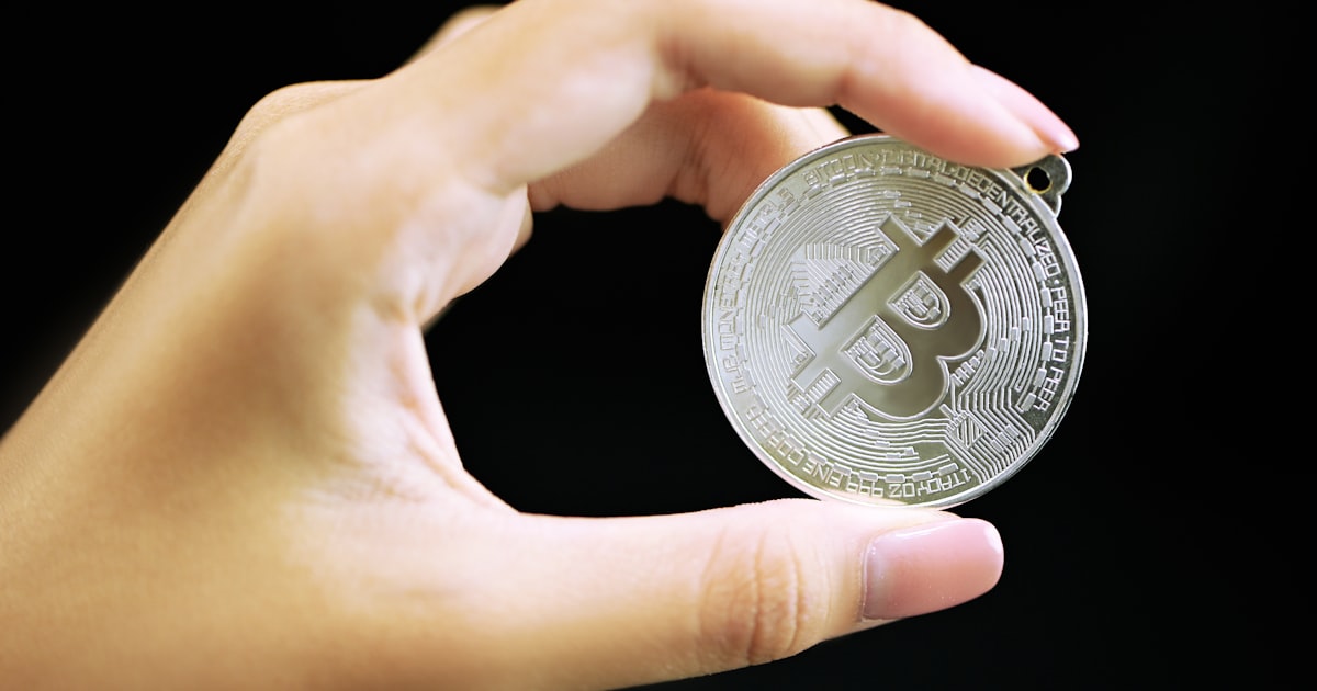 person holding silver round coin