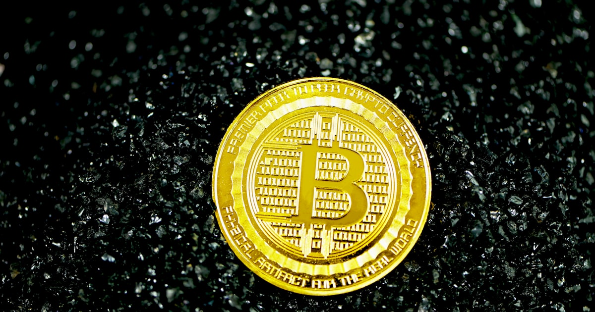 gold round coin on black surface