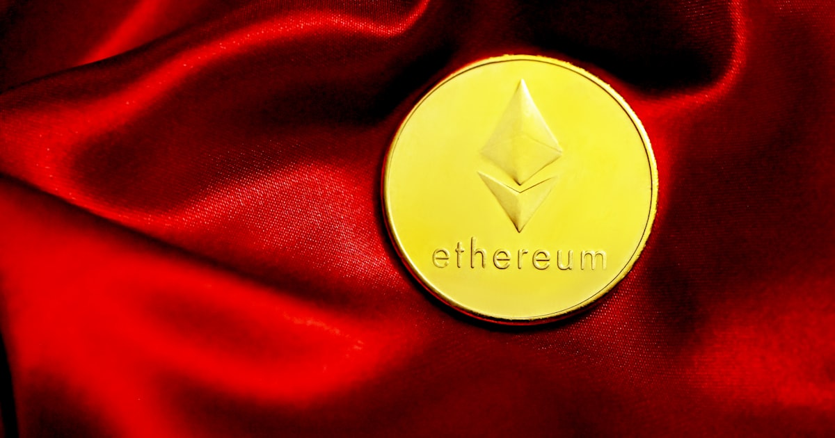 a close up of a red cloth with a gold coin