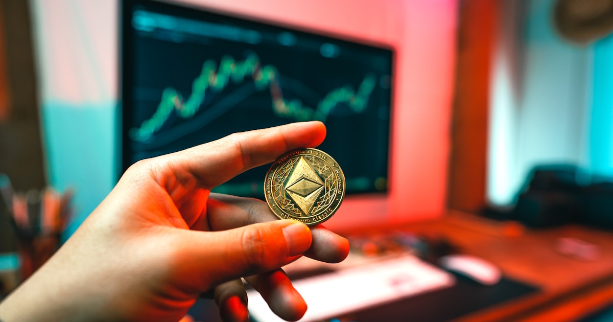 a person holding a coin in front of a computer
