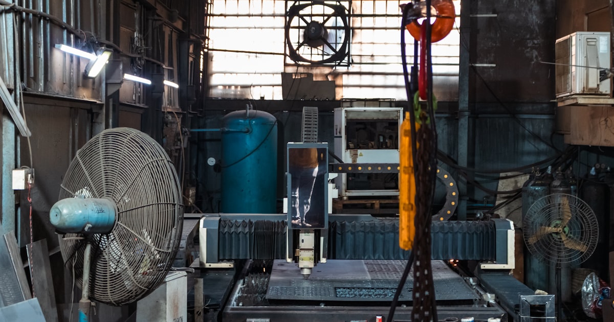 Industrial workshop with machinery and fans.