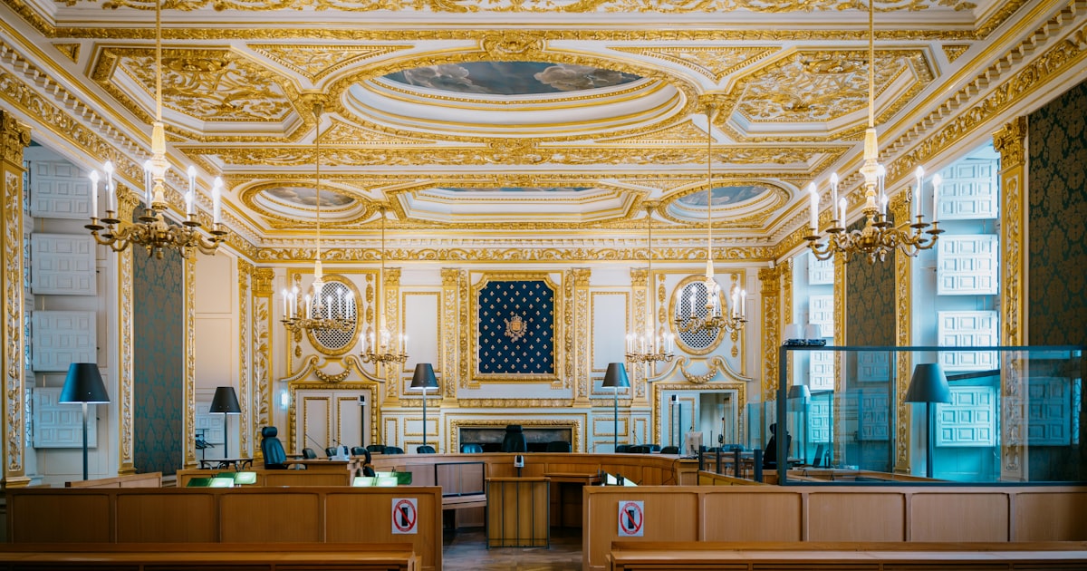 Ornate courtroom with gilded decorations and chandeliers