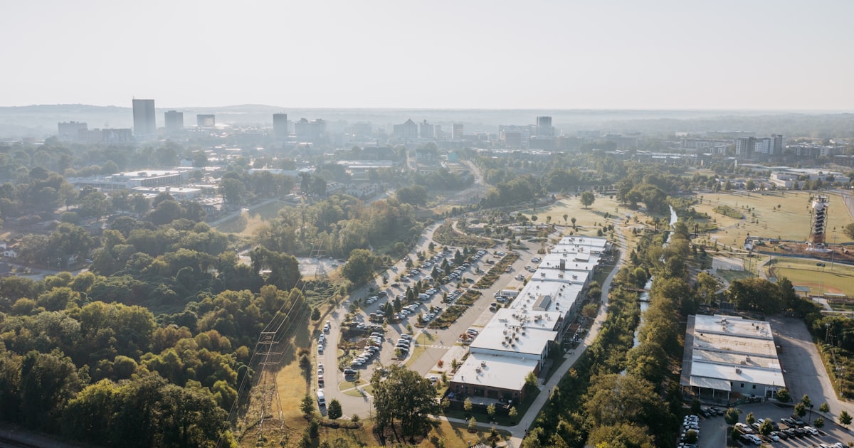 Aerial view of suburban buildings and distant city skyline.