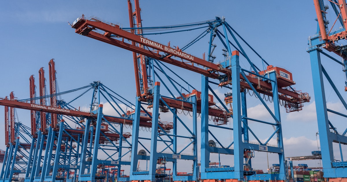 Cargo cranes stand tall at a bustling port.