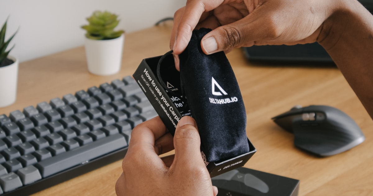 person holding black and white adidas pouch