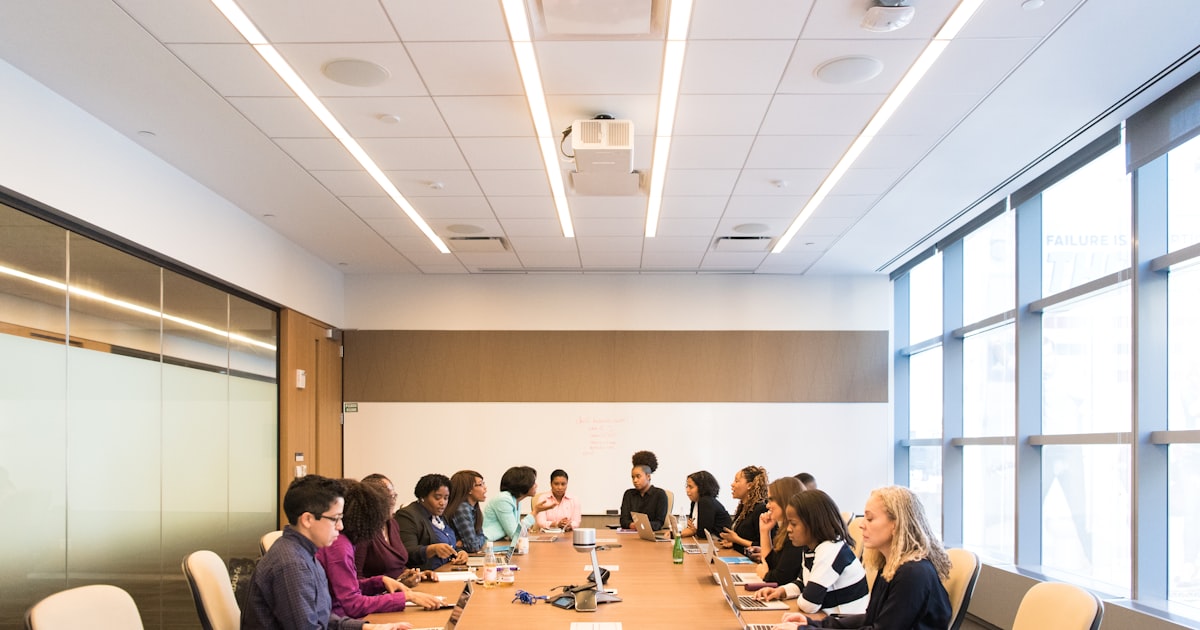people having meeting on rectangular brown table