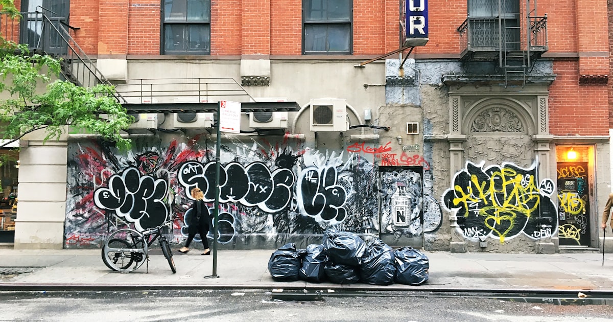man standing near calligraphy wall