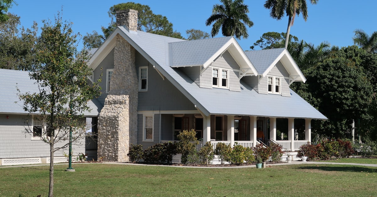 brown and white concrete house near green grass field during daytime