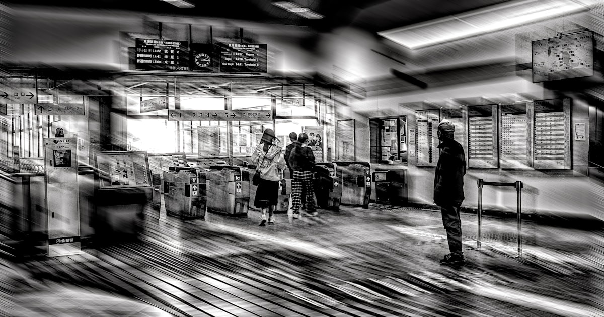 People at a blurred train station entrance