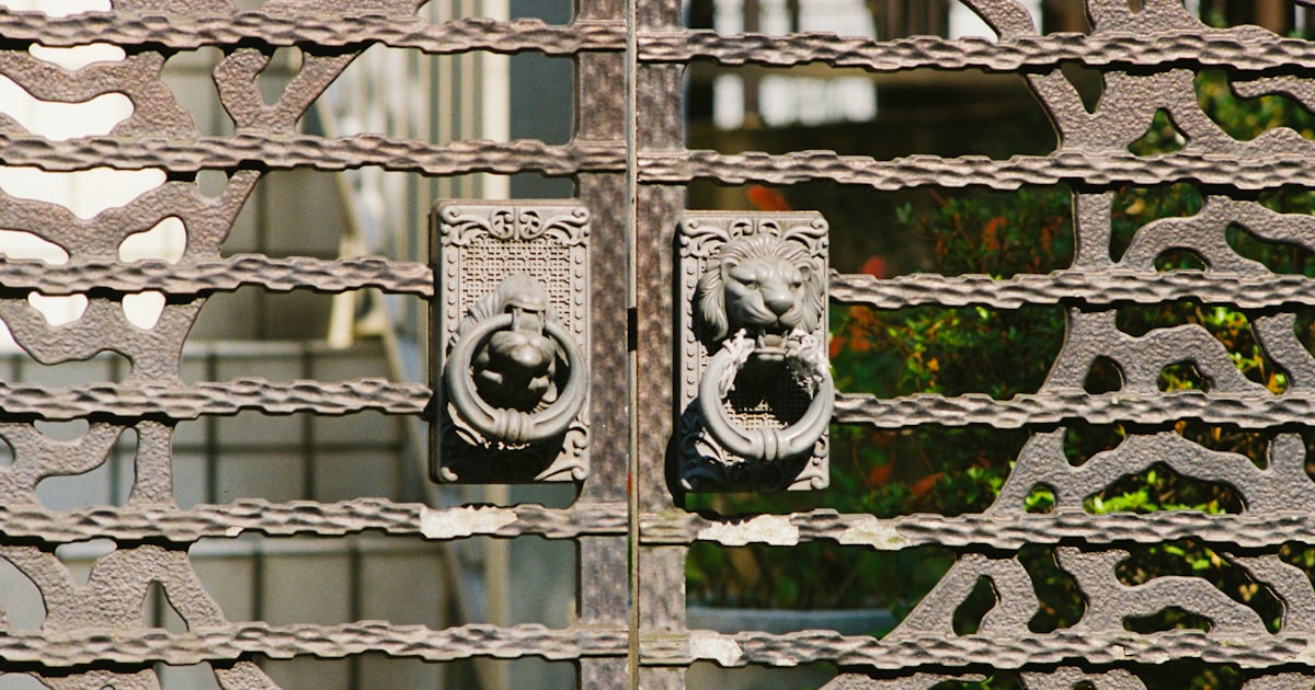 A close up of a metal gate with decorative designs